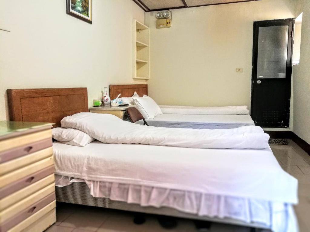 - une chambre avec 3 lits et une commode dans l'établissement Xia Xing Inn, à Jinhu