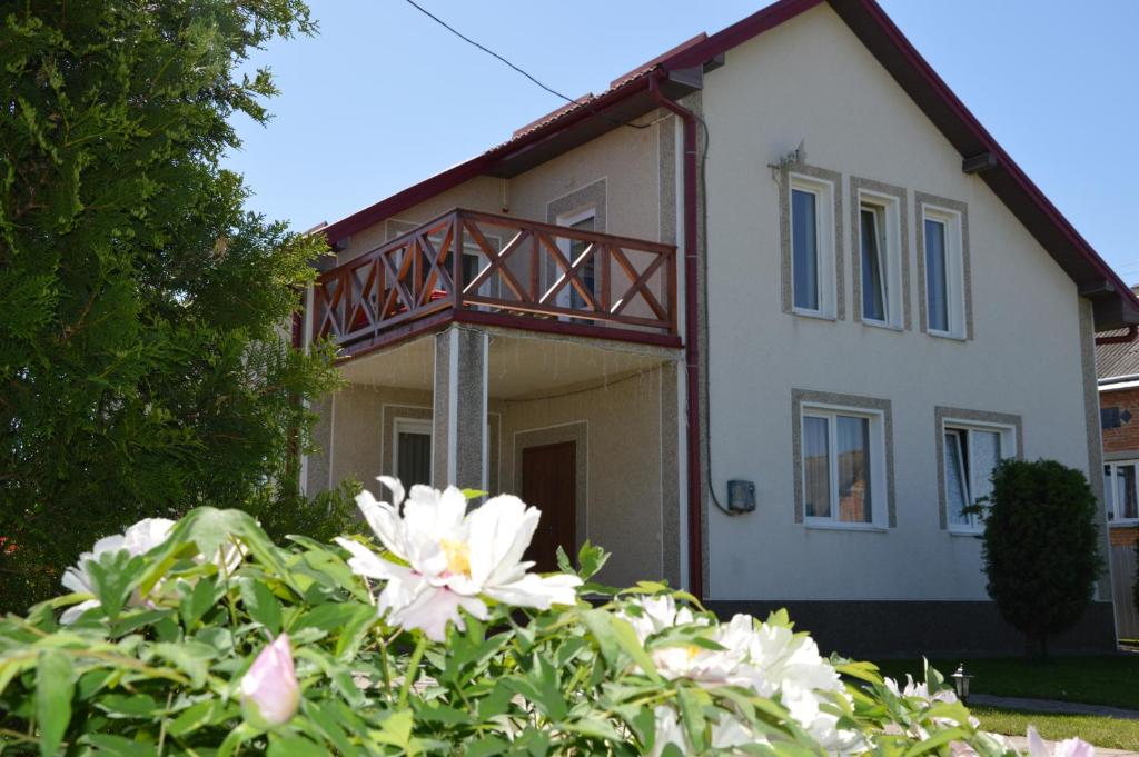 una casa blanca con una pasarela de madera delante de ella en Villa & SPA Owerko, en Chishki