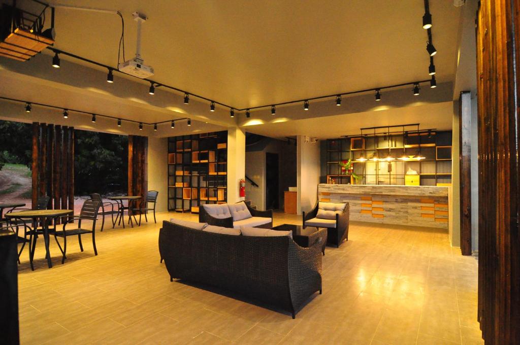 a living room with couches and chairs and a table at Saipan Skyline Designers Hotel in Saipan