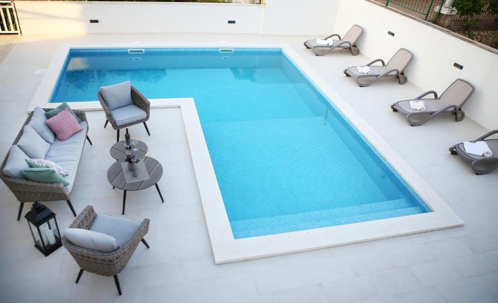 an overhead view of a swimming pool with chairs and tables at Apartments Villa Julija in Lumbarda