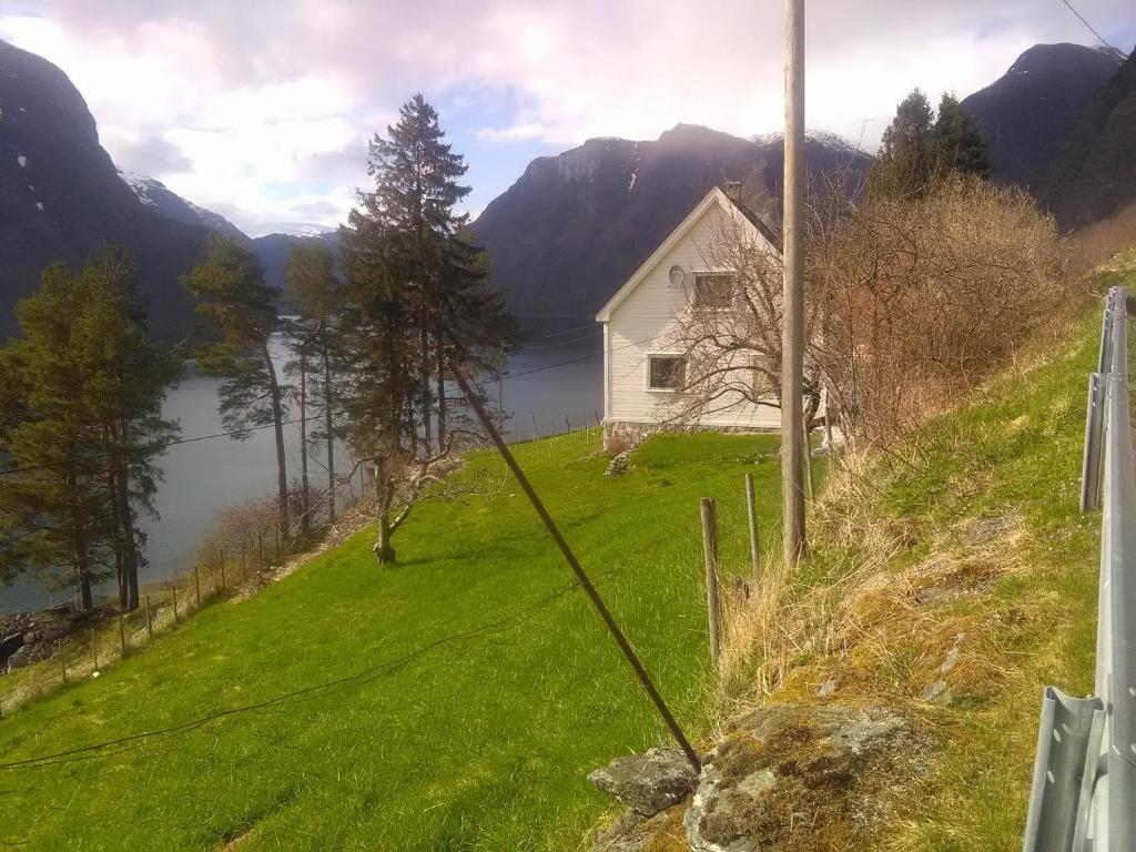 a house on a hill next to a lake at Kvam - Stegastein in Aurland