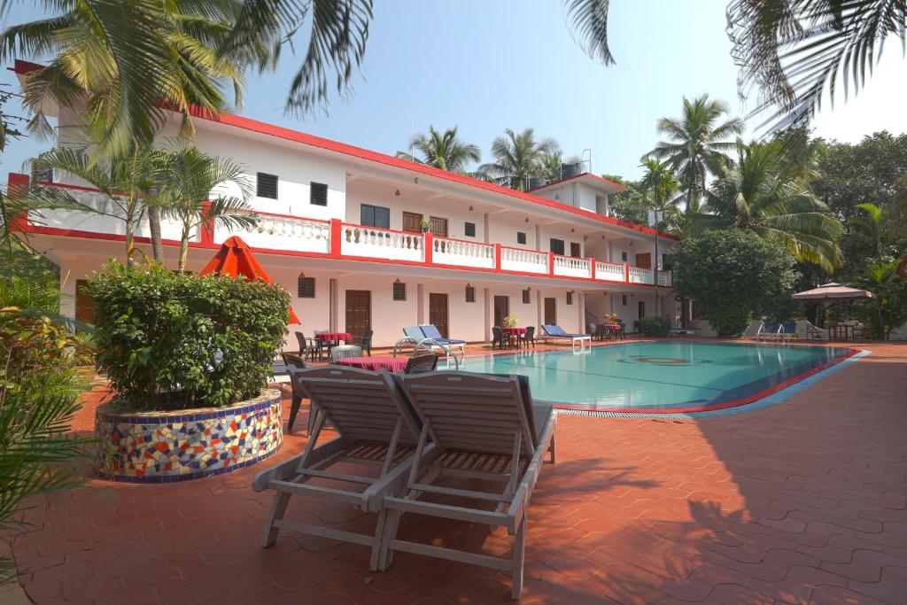 a resort with two chairs and a swimming pool at Anjuna Beach Resort in Anjuna