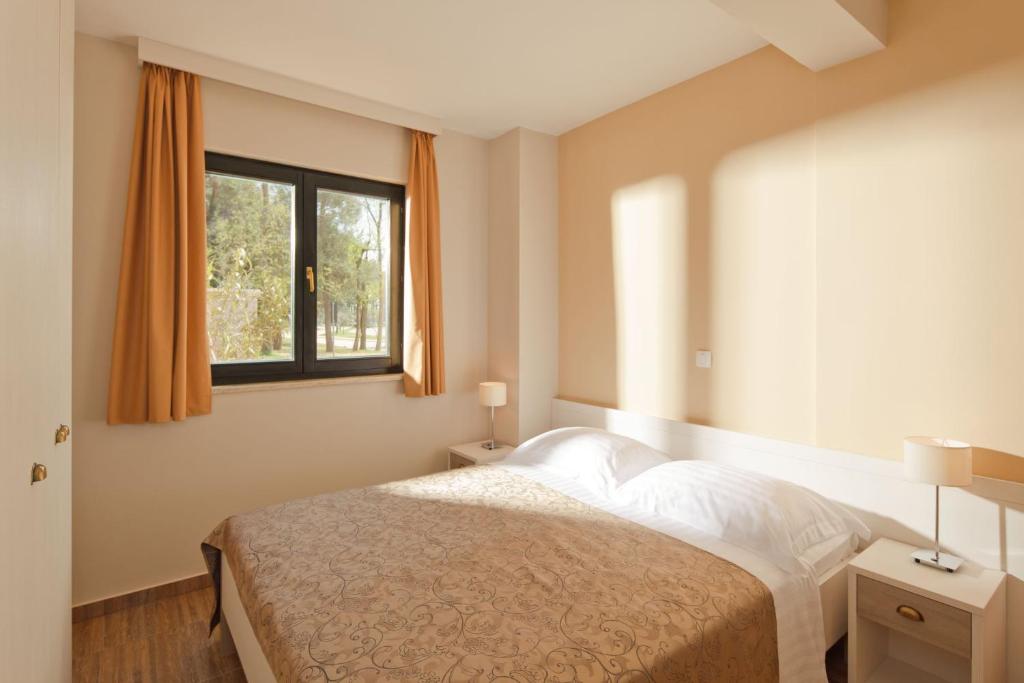 Postel nebo postele na pokoji v ubytování Apartments Amfora Plava Laguna