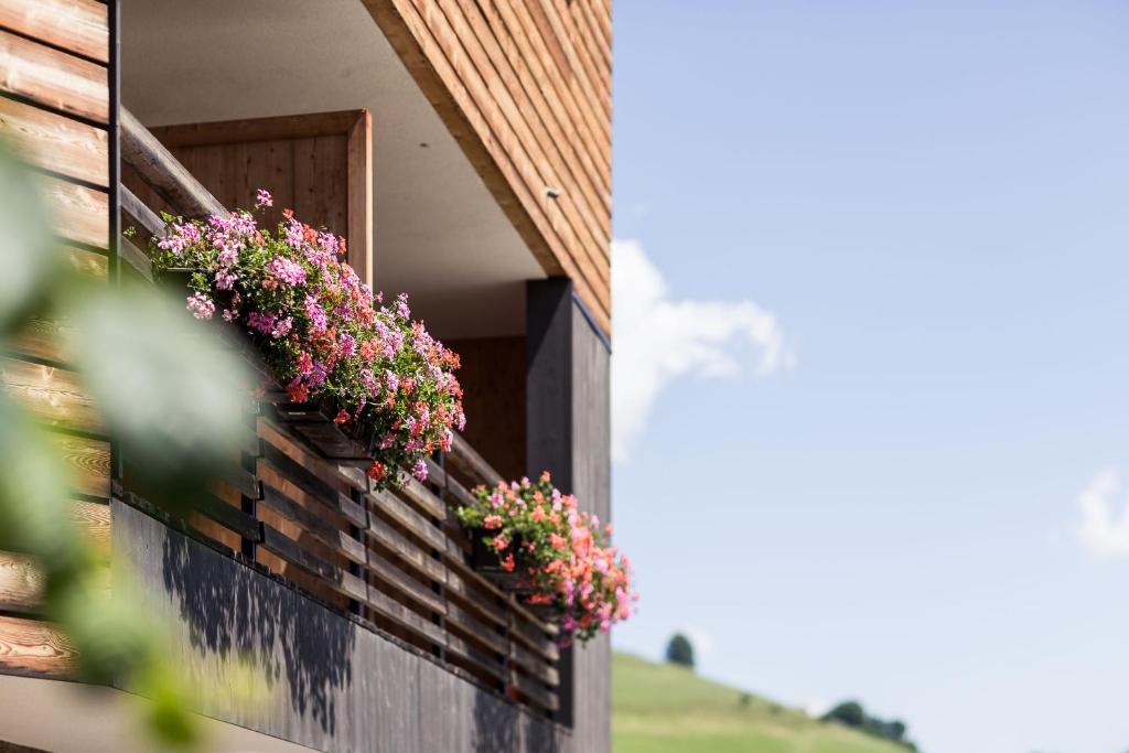 a balcony with flower boxes on the side of a house at Hotel Dolomitenblick in Terento