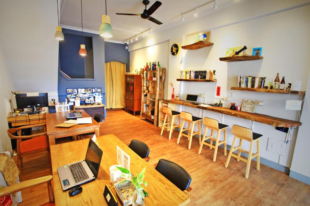 a restaurant with tables and chairs and a bar at Navel Orange Hostel in Taitung City