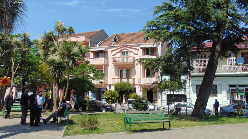 a group of people standing in front of a pink building at Old Street Guesthouse in Batumi