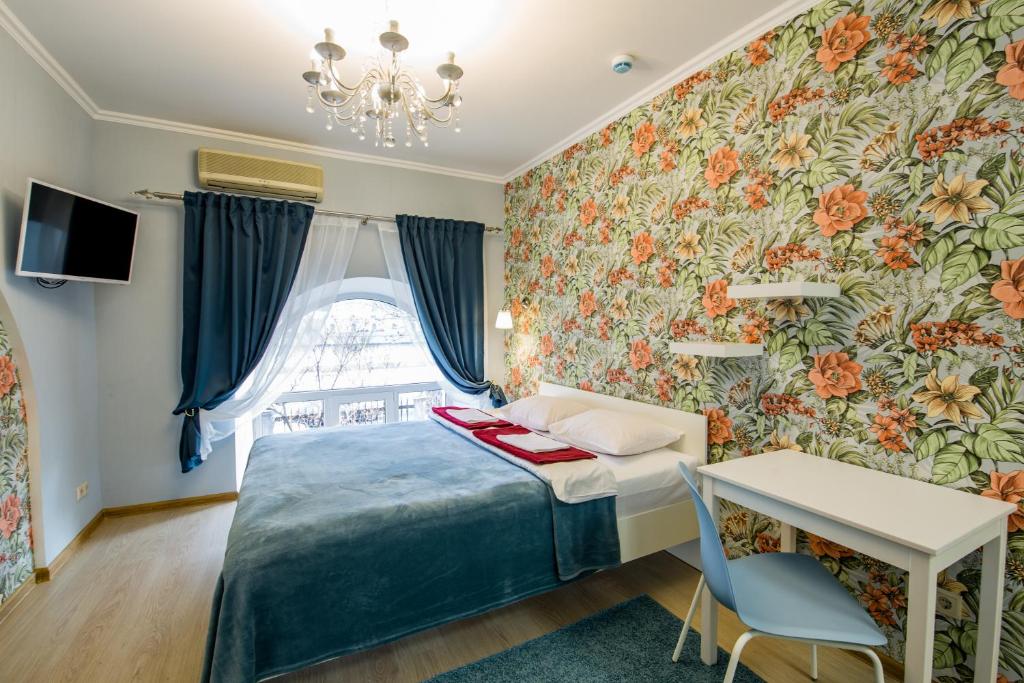 モスクワにあるVoyage Mini-hotelのベッドルーム1室(ベッド1台、テーブル、窓付)