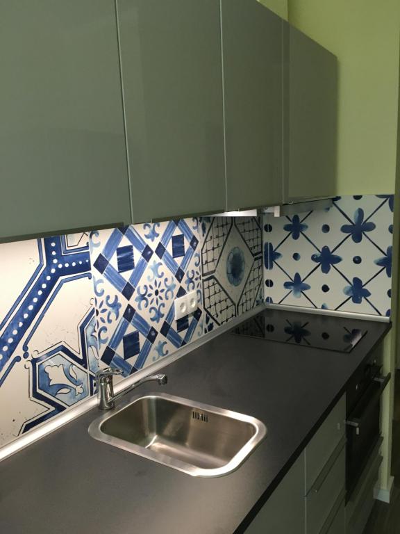 eine Küche mit einem Waschbecken und blauen und weißen Fliesen in der Unterkunft Villa Cosima in Bansin