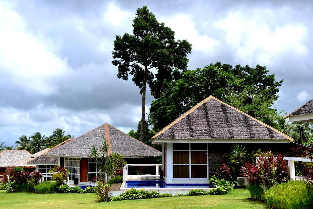 uma casa com uma árvore no quintal em Recidencia Del Hamor em Casiguran