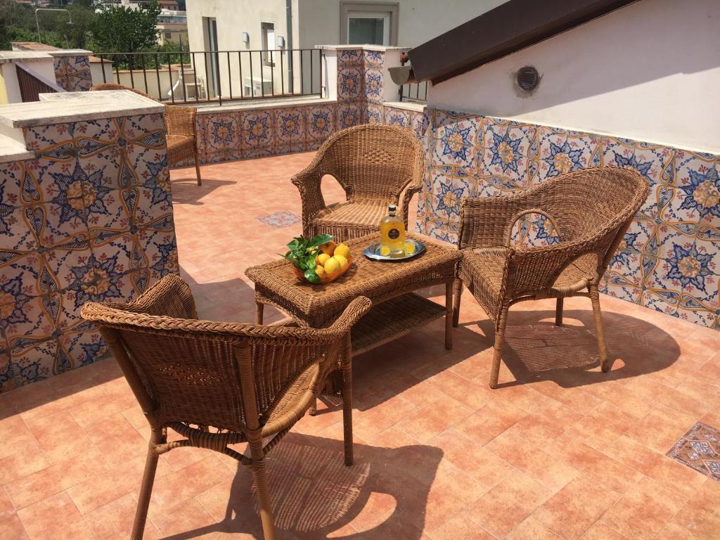 un patio con sillas y una mesa con un bol de fruta en Maison de Charme Iommella, en Sant'Agnello