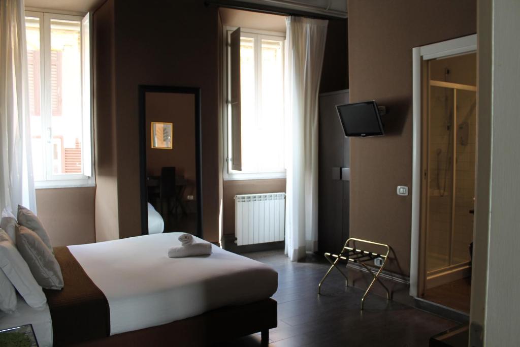 1 dormitorio con 1 cama y TV en Relais Palazzo Taverna, en Roma