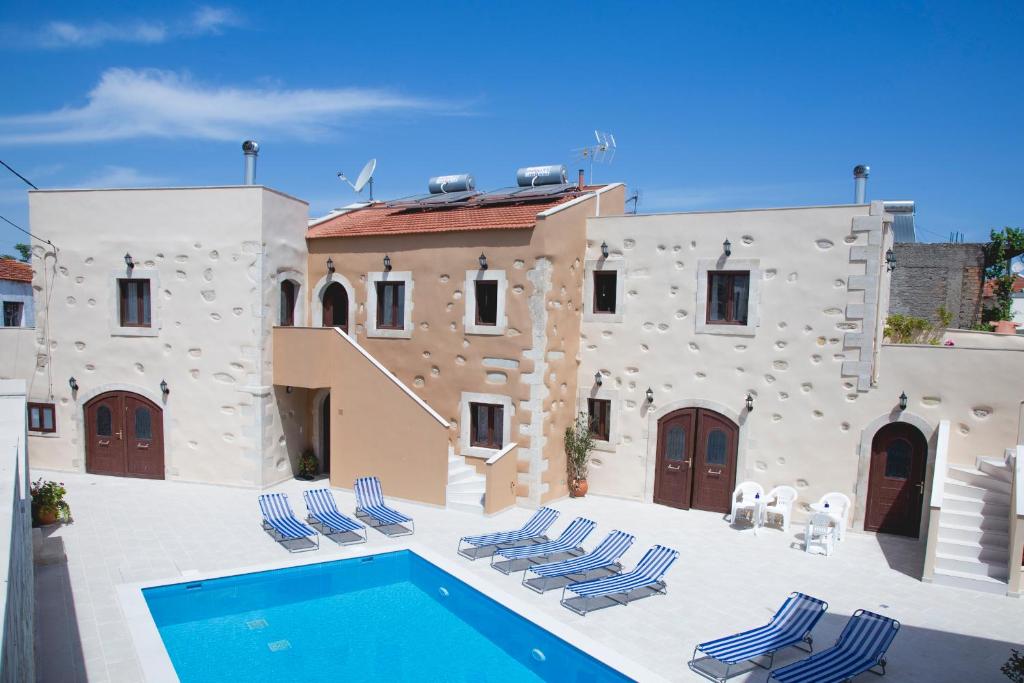 a villa with a swimming pool in front of a building at Villa Cardia in Kiriánna