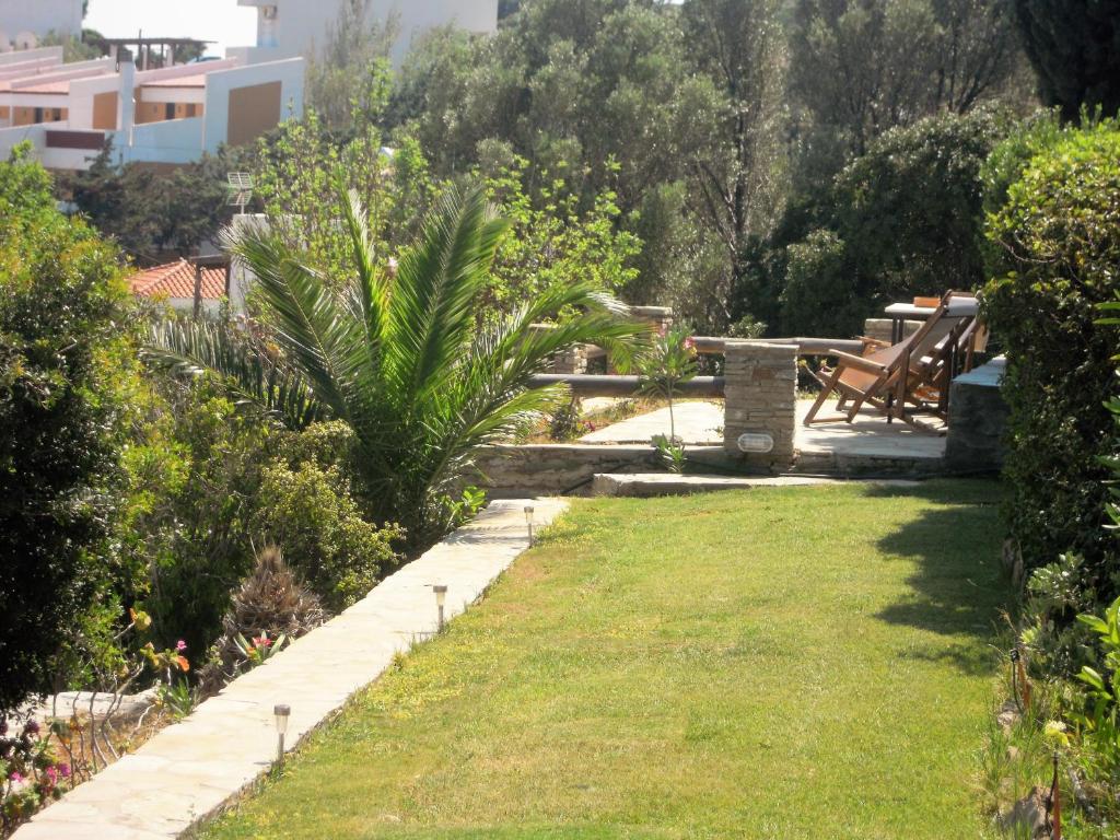a garden with a bench and grass and bushes at Blue Dolphin in Batsi