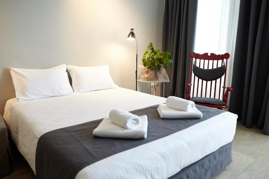 sypialnia z białym łóżkiem i ręcznikami w obiekcie DreamHouse 1 - Komotini w mieście Komotini
