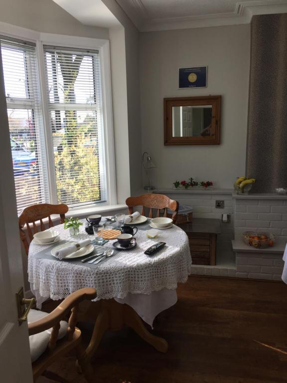 a dining room table with a white table cloth at Southend Airport Bed & Breakfast in Rochford