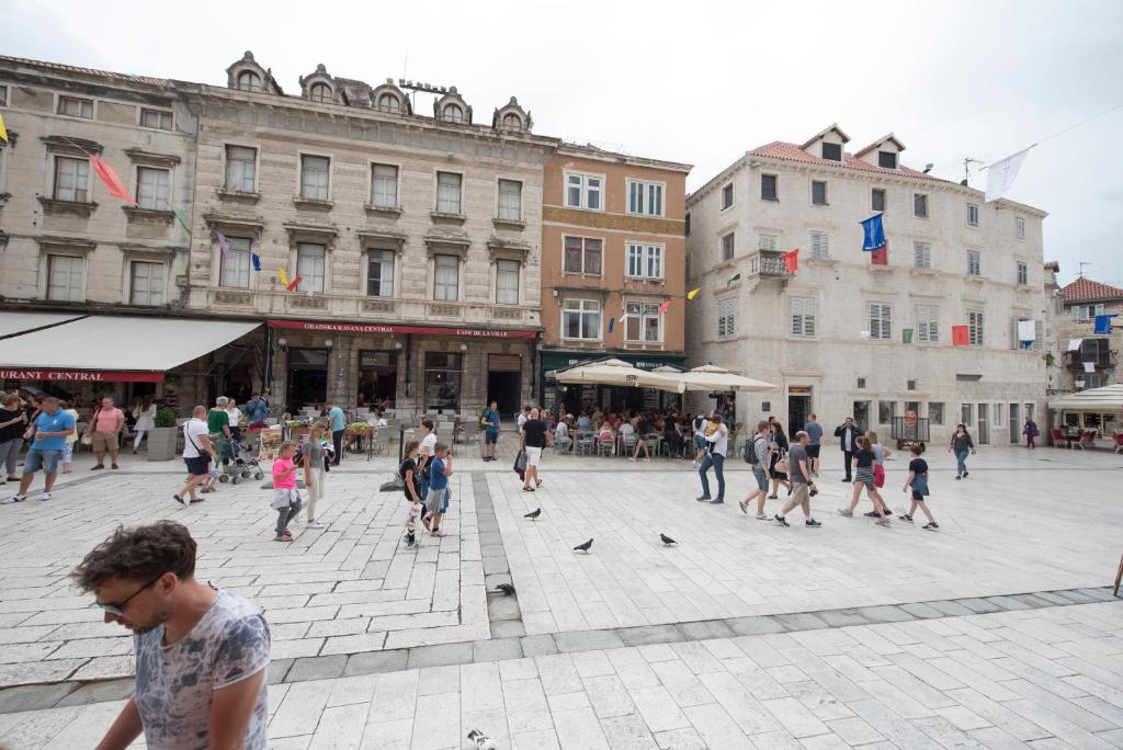 Un groupe de gens se promenant dans une place dans l'établissement Piazza Square City Top Centre Apartments, à Split