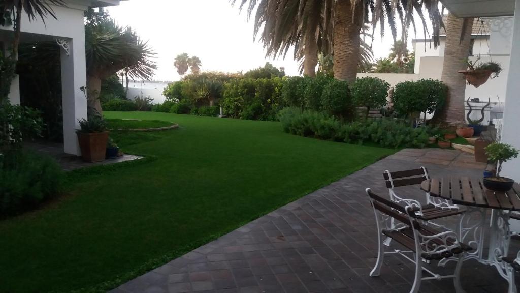 a yard with green grass and a table and chairs at Haus Schaaf b&b in Walvis Bay