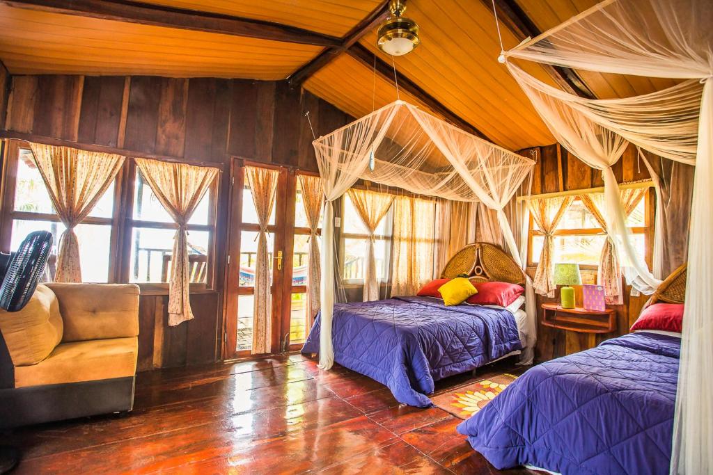 a bedroom with two beds and a couch and windows at Redwood Beach Resort in Mechapa