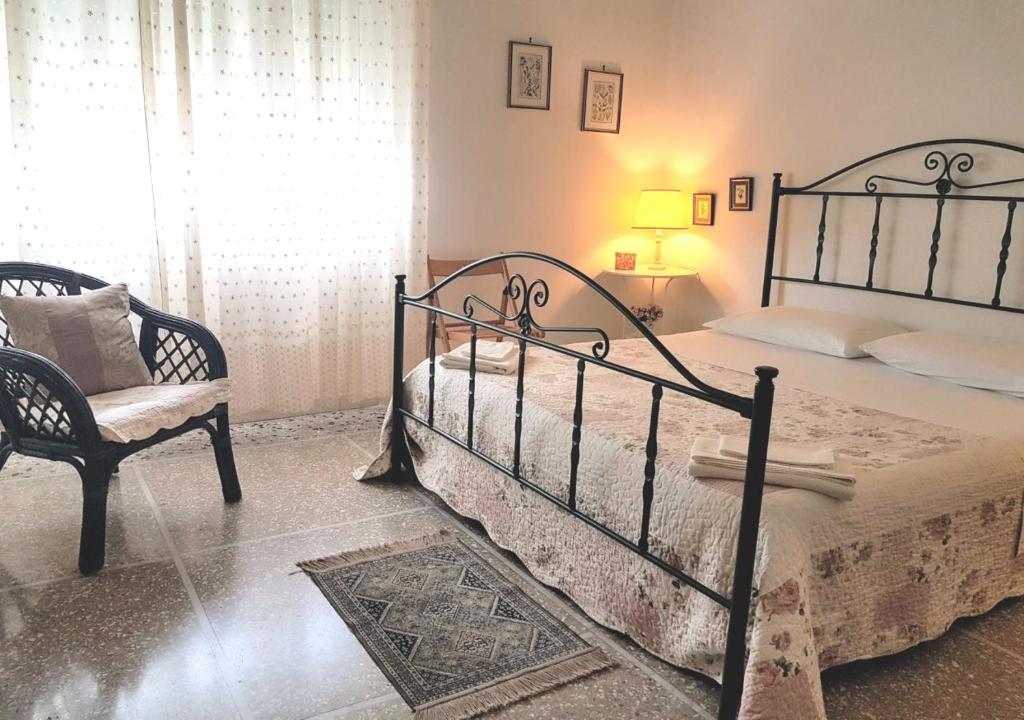 ein Schlafzimmer mit einem Bett und einem Stuhl in der Unterkunft La Coccinella Guest House Self Check-in in Pisa