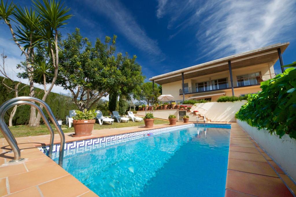 a swimming pool in front of a house at Villa Gaudí in L'Ampolla