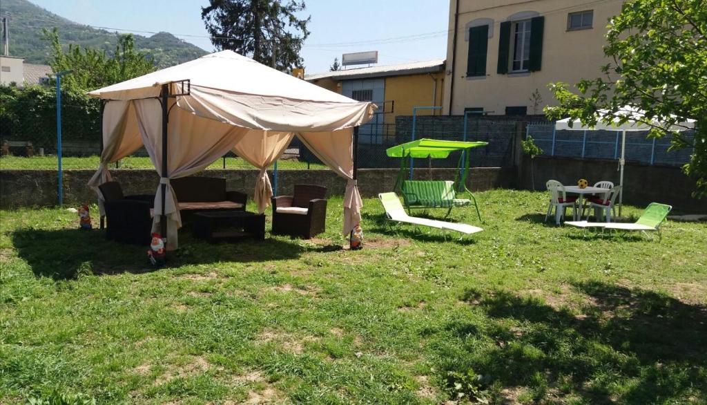 a tent in a yard with chairs and a table at Appartamento Porzione di villa "il cappello d'oro" in Chiavari