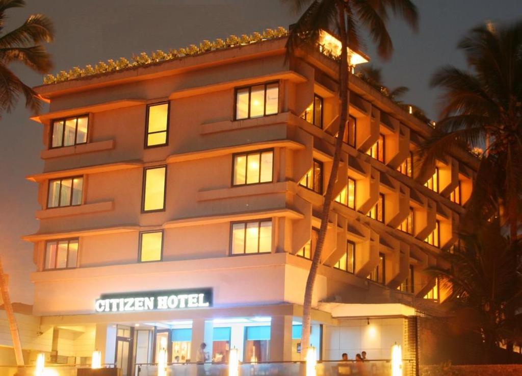 a hotel building with a sign on it at night at Citizen Hotel in Mumbai