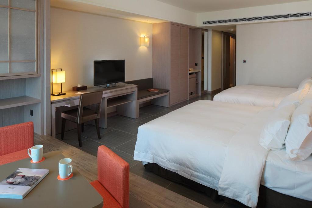 Habitación de hotel con cama y escritorio con TV. en Fullon Hotel LihPao Resort, en Houli
