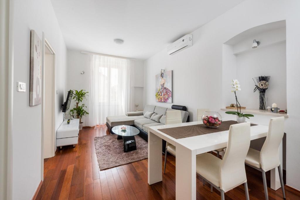 a white living room with a table and a couch at Fairy Of The Seas Apartments in Split