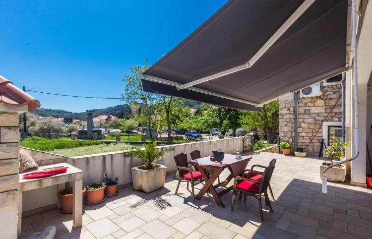 a patio with a table and chairs and an umbrella at Slanac 3 in Veli Iž