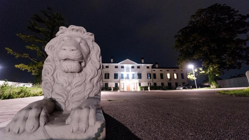 posąg lwa przed budynkiem w obiekcie Villa Marini Trevisan w mieście Aviano