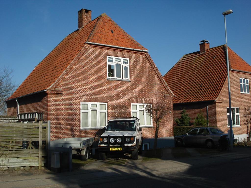 een auto geparkeerd voor een bakstenen huis bij Jysse's Bed & Bath in Nykøbing Sjælland
