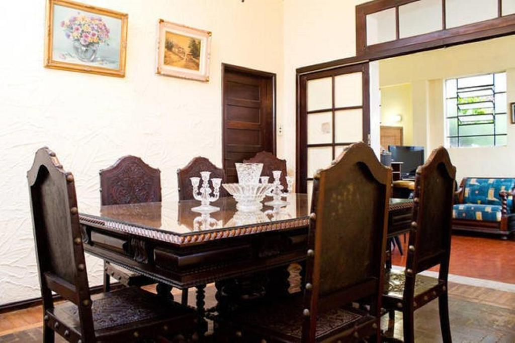 a dining room with a wooden table and chairs at Tião Botelho Guest House in Rio de Janeiro