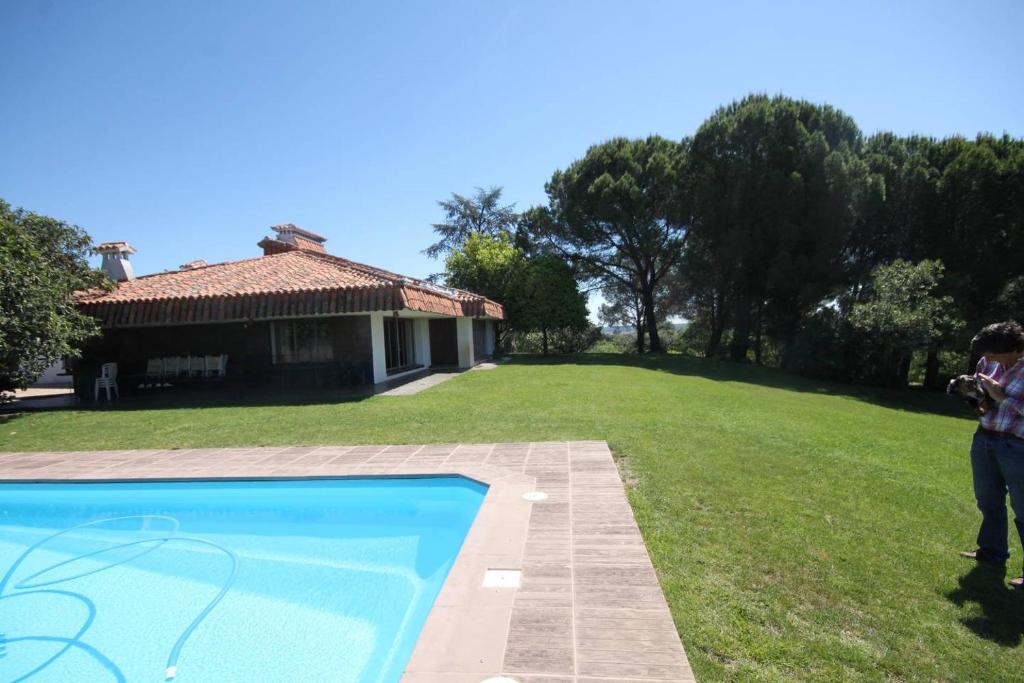 a person taking a picture of a house and a swimming pool at Casa Rural El Rivero in Jaraiz de la Vera