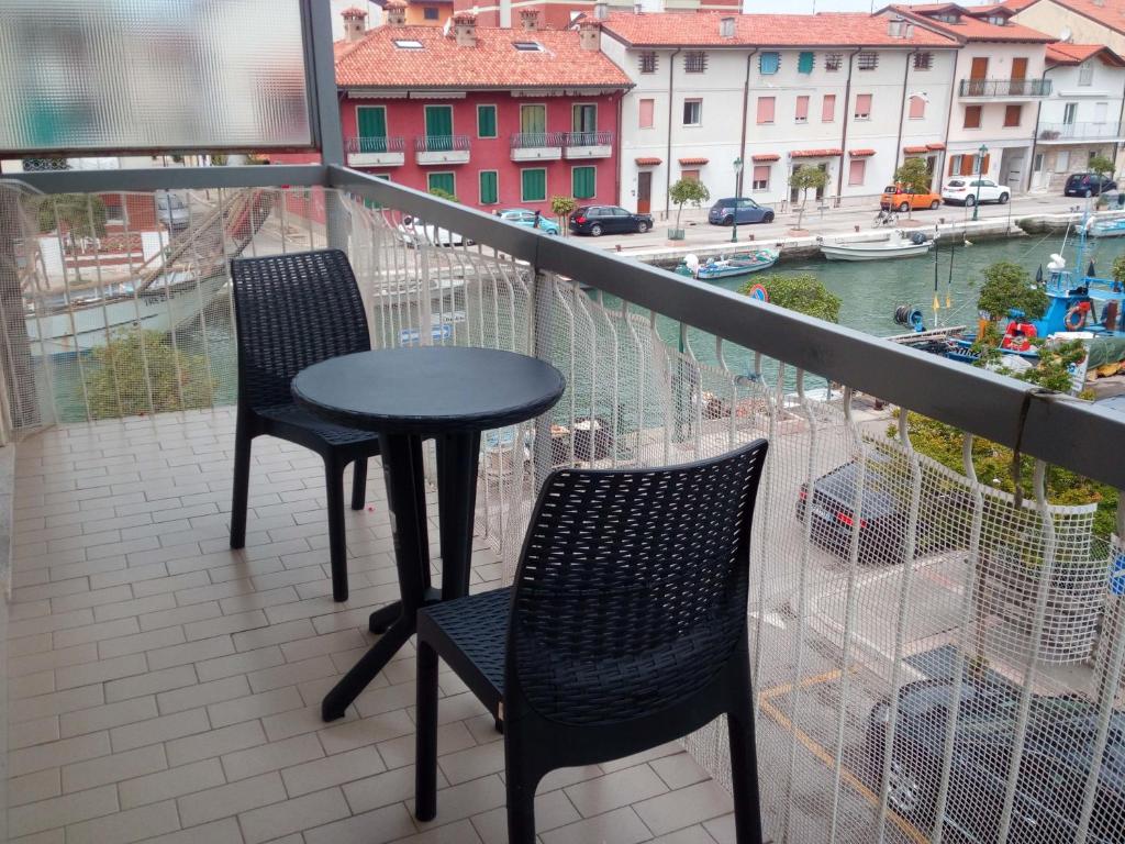 a balcony with two chairs and a table on a balcony at Appartamento Perco Riva Dandolo in Grado