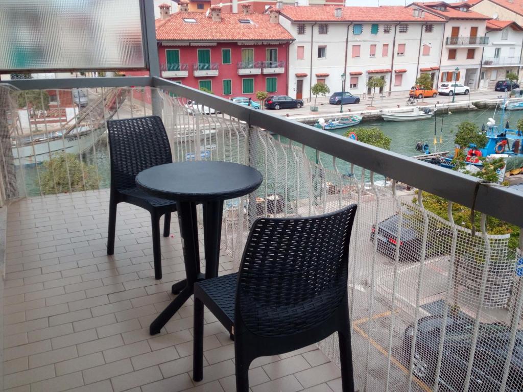 グラードにあるAppartamento Perco Riva Dandoloのバルコニー(椅子2脚、テーブル付)