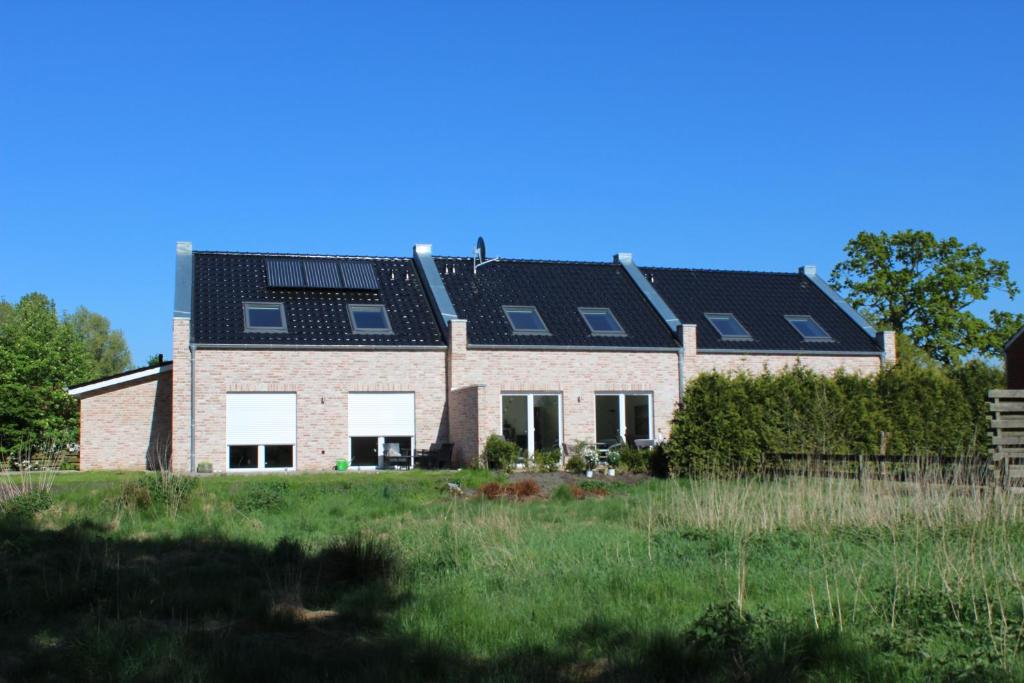uma casa com painéis solares por cima em Ferienhaus Westwind em Rhauderfehn