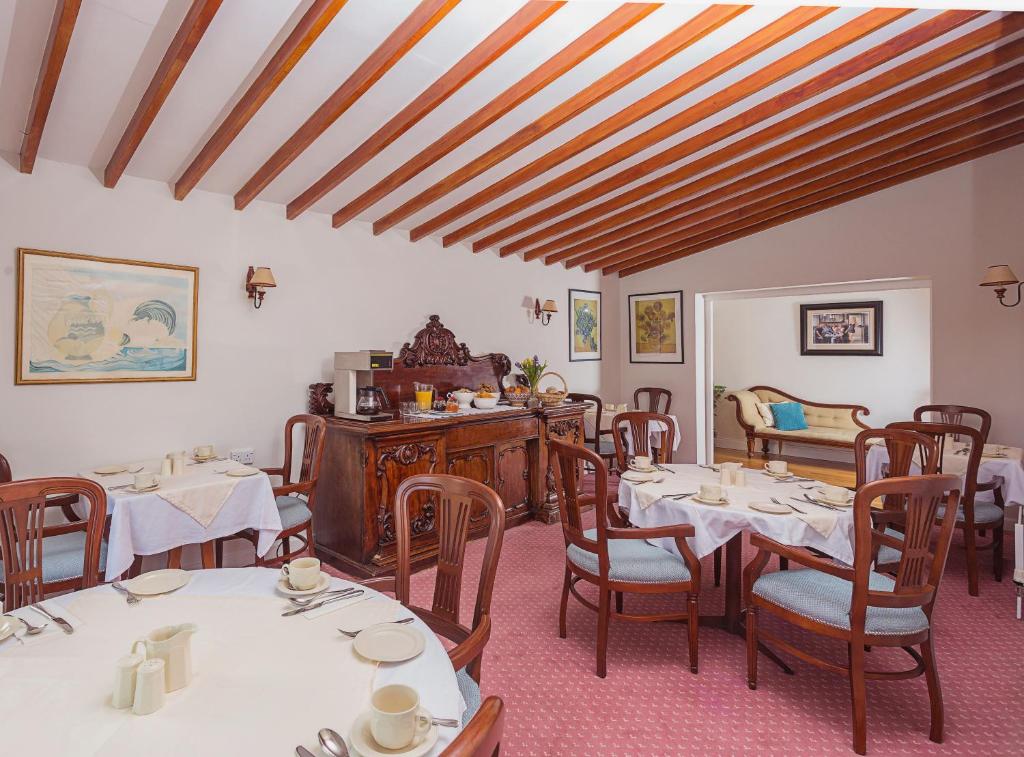 jadalnia ze stołami i krzesłami w pokoju w obiekcie Ardree House B&B w Killarney