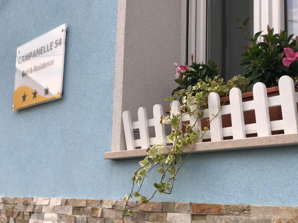 uma janela com uma cerca branca e uma placa num edifício em Residence Campanelle 54 em Trieste