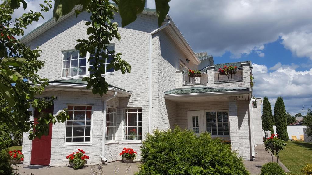 una casa blanca con flores en las ventanas en Helene Villa, en Kuressaare