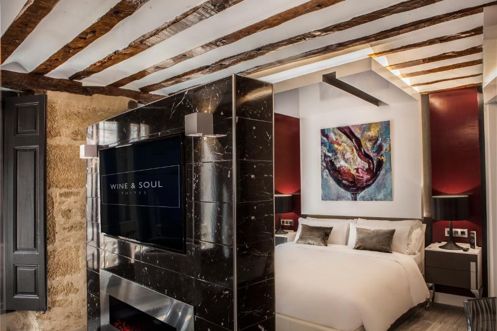 a bedroom with a bed and a wall with a tv at Wine & Soul Suites in Haro