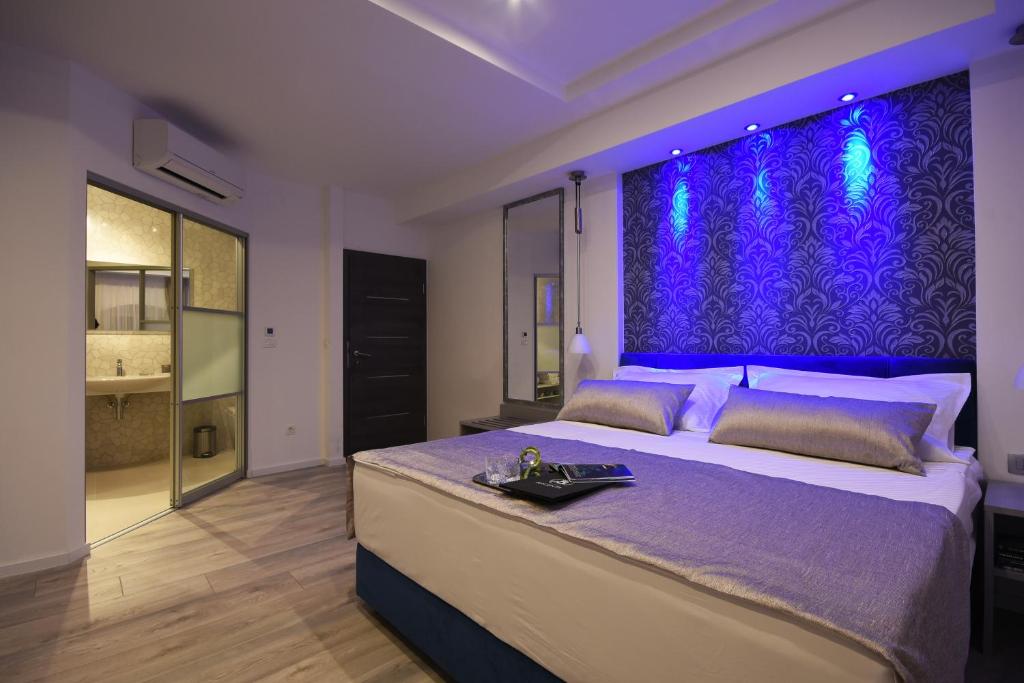 - une chambre avec un grand lit et un mur pourpre dans l'établissement Argenta Luxury Room, à Split