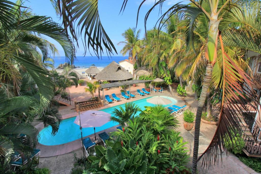 - une vue aérienne sur la piscine du complexe bordée de palmiers dans l'établissement Hotel Santa Fe, à Puerto Escondido