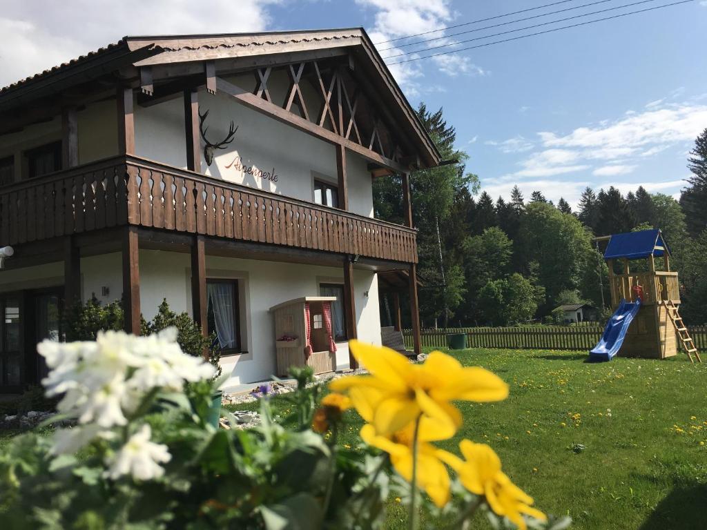 グライナウにあるFerienhaus Alpenperleのバルコニー付きの家、花の咲く庭