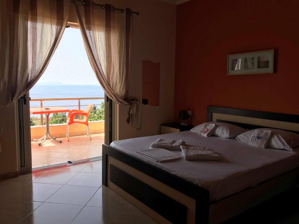 a bedroom with a bed and a view of the ocean at Dhori House Dhermi in Dhërmi