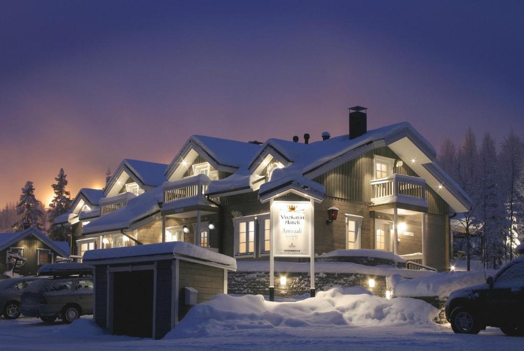 a house covered in snow at night at Vuokatin Aateli Apartments in Vuokatti