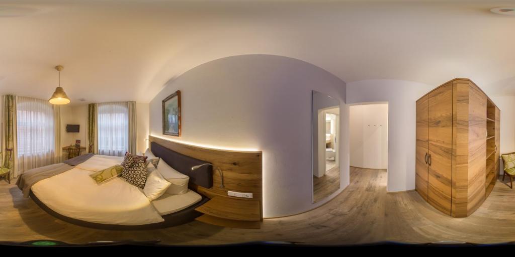 ein Wohnzimmer mit einem Bett und ein großes Zimmer mit in der Unterkunft Adler Oberdorf in Langenargen