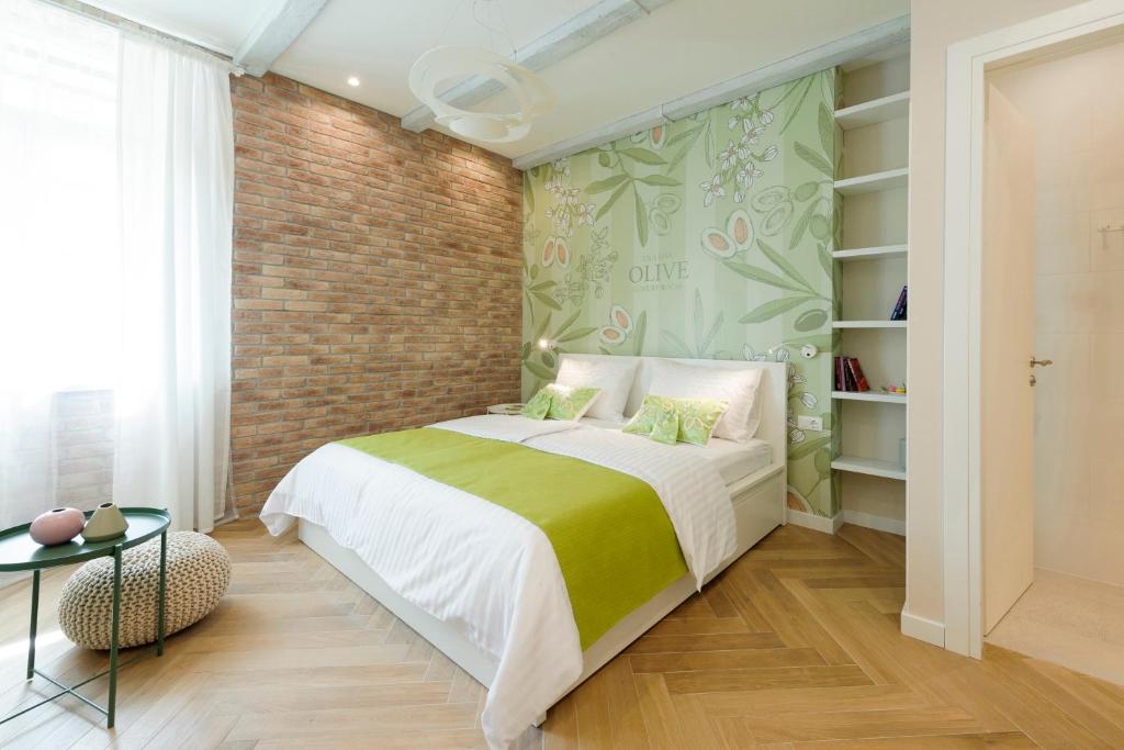 ein Schlafzimmer mit einem Bett und einer Ziegelwand in der Unterkunft Mak Luxury Rooms in Split