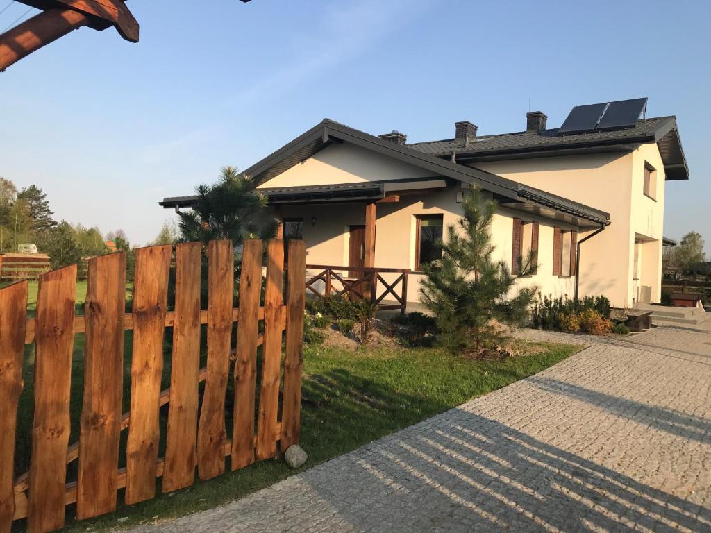 une maison avec une clôture en bois devant elle dans l'établissement Na Skraju Puszczy, à Hajnówka