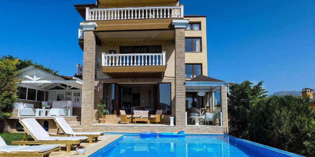 a house with a swimming pool next to a building at Villa Deluxe Sight in Ioannina