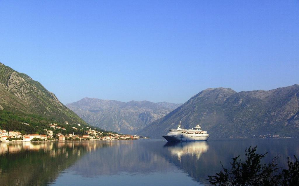 a cruise ship in a large body of water with mountains at Melodia del Mare 2 in Kotor